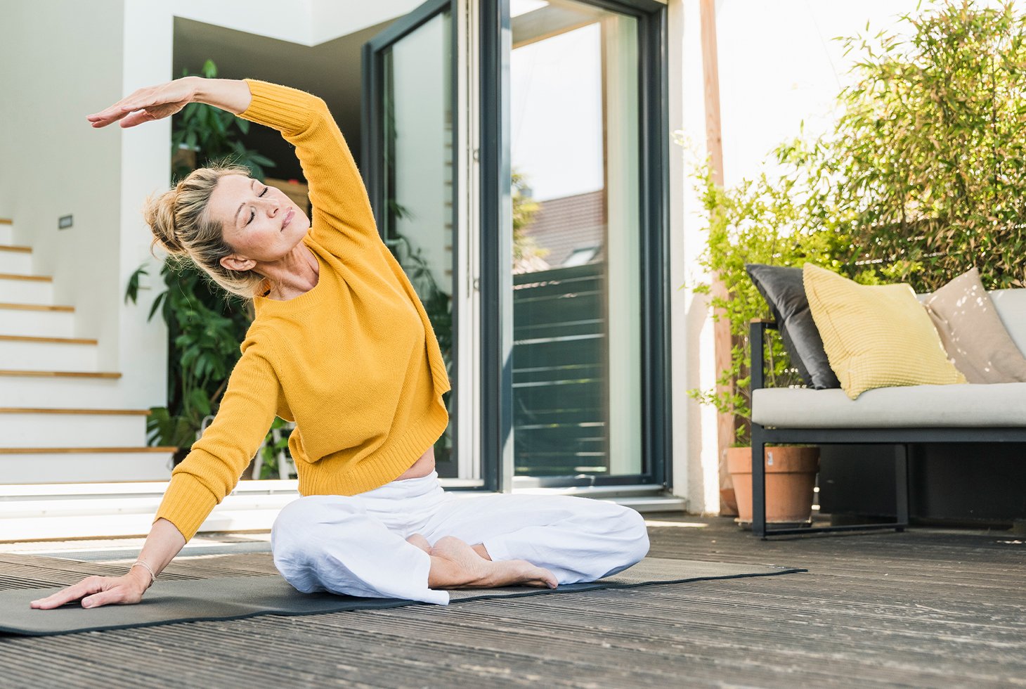 Femme effectuant une posture de Yoga (étirements en position assise), une activité sportive recommandée pour le renforcement des muscles du périnée