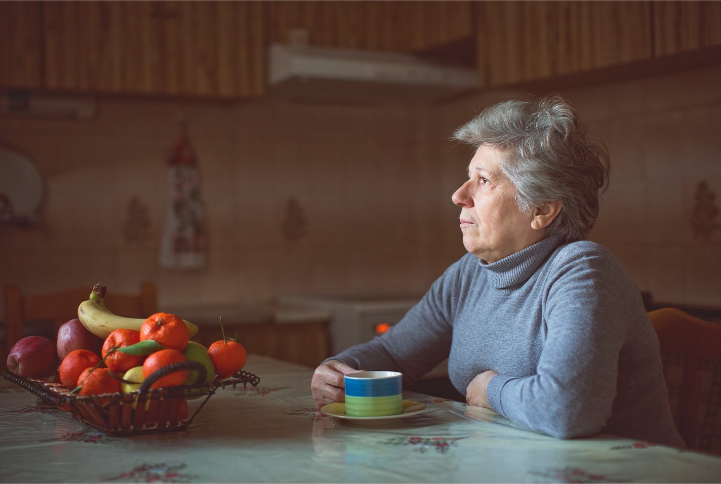 Portrait d’une femme senior prenant un café dans sa cuisine. Visuel pour illustrer la thématique de l’incontinence chez les personnes âgées.