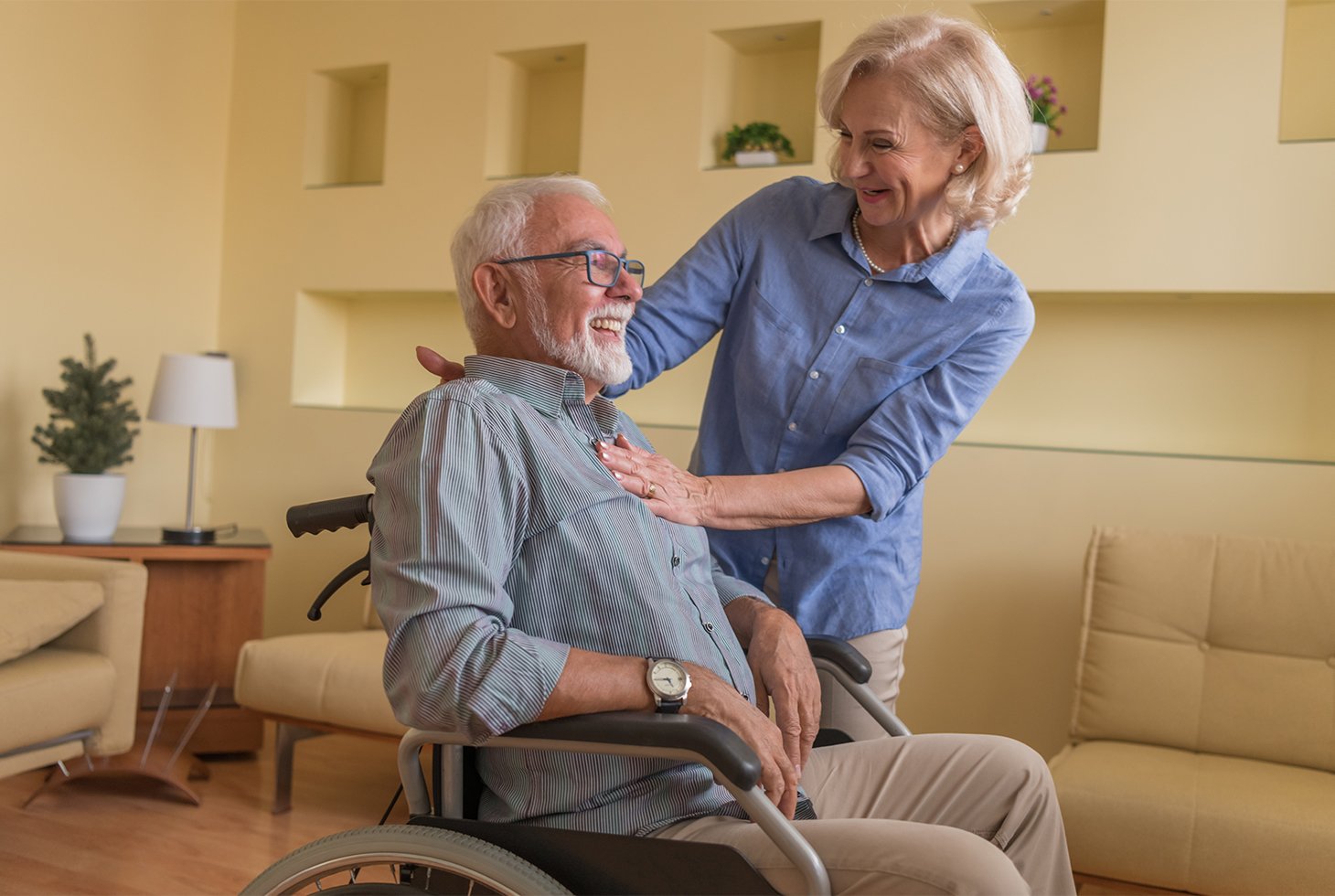 Un senior en fauteuil roulant, échange de manière joviale avec sa femme. Visuel pour illustrer les solutions adaptées pour gérer l’incontinence en situation de handicap.