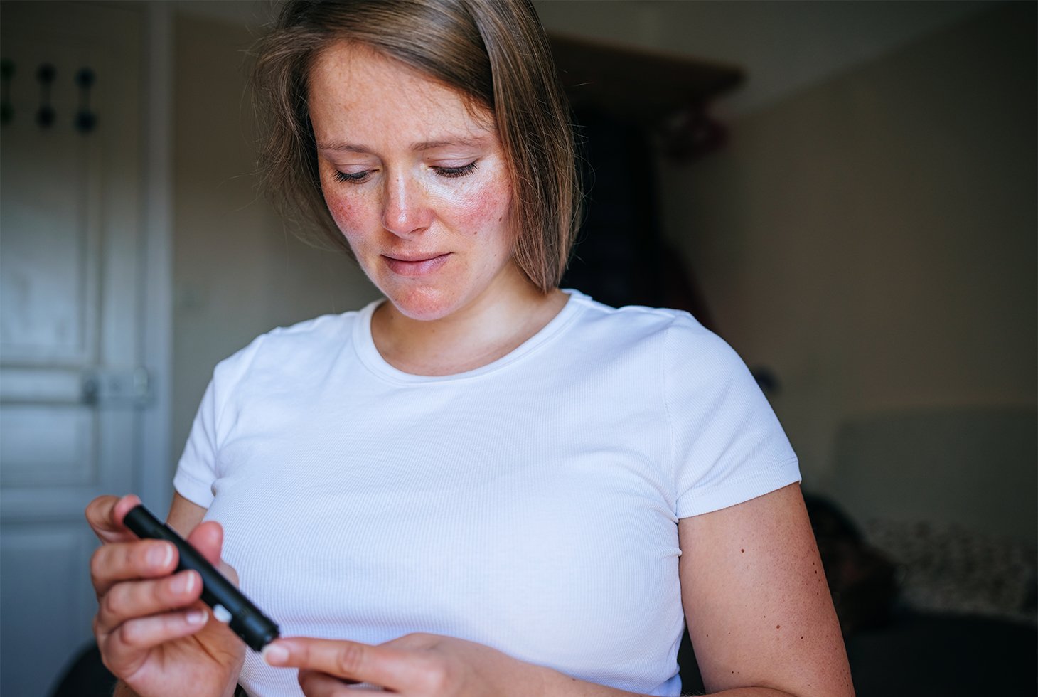 Une femme mesurant sa glycémie à l’aide d’un stylo autopiqueur