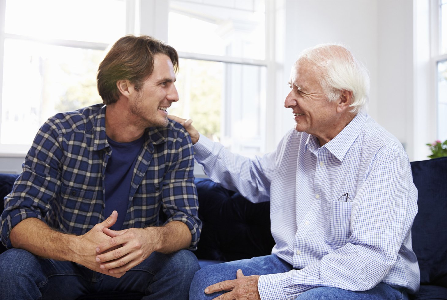 Une personne âgée discute en souriant avec un proche âgé d’une trentaine d’années