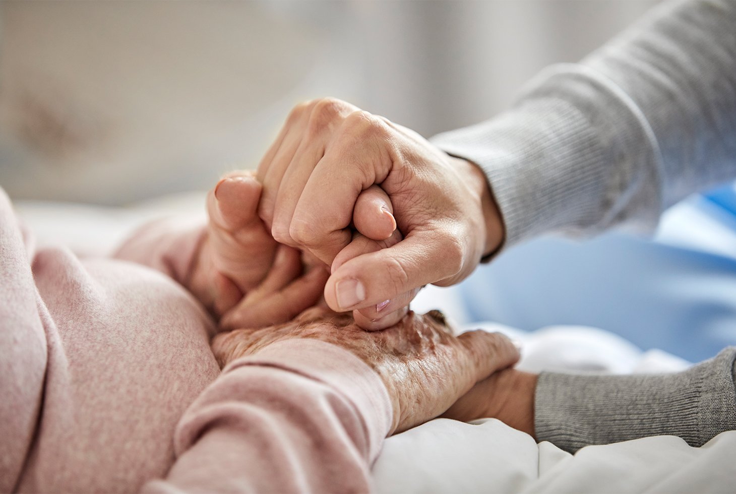 Plan cadré sur des mains : celles d’un proche tenant les mains d’une personne âgée en signe de réconfort. Visuel pour illustrer le rôle des aidants familiaux dans l’accompagnement d’une personne dépendante